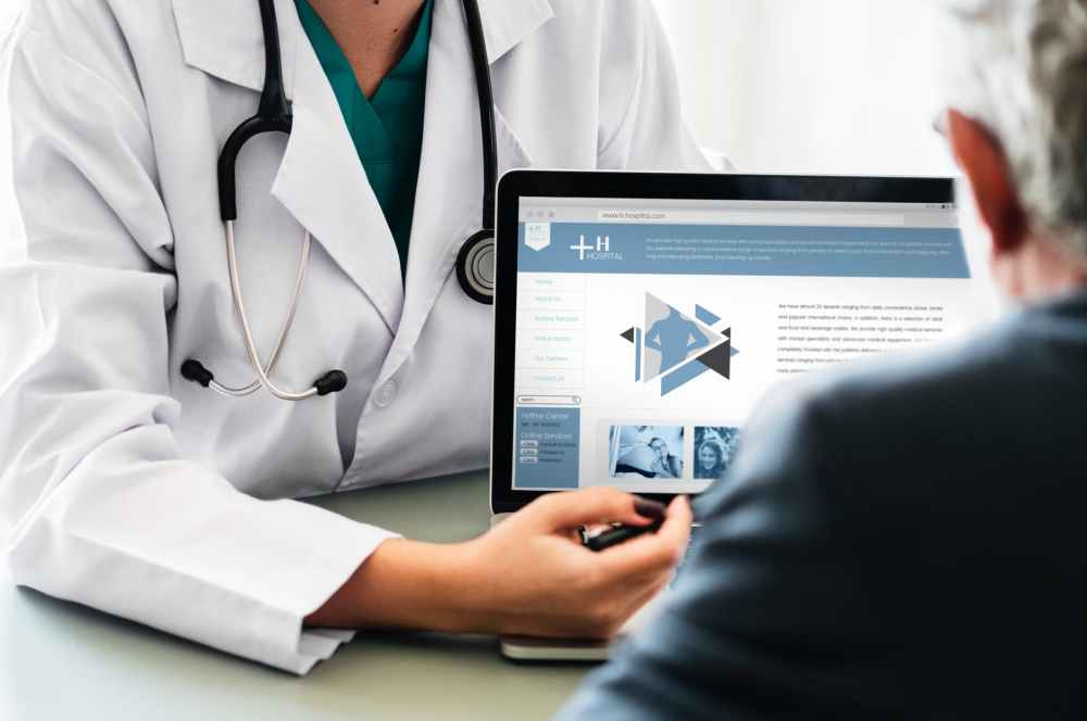 doctor pointing at tablet laptop